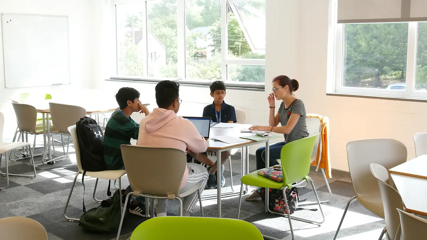 A small-group tutorial on a college lawn