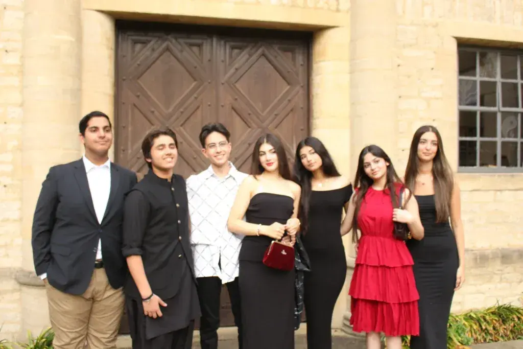 Programme participants in formal dress outside a college