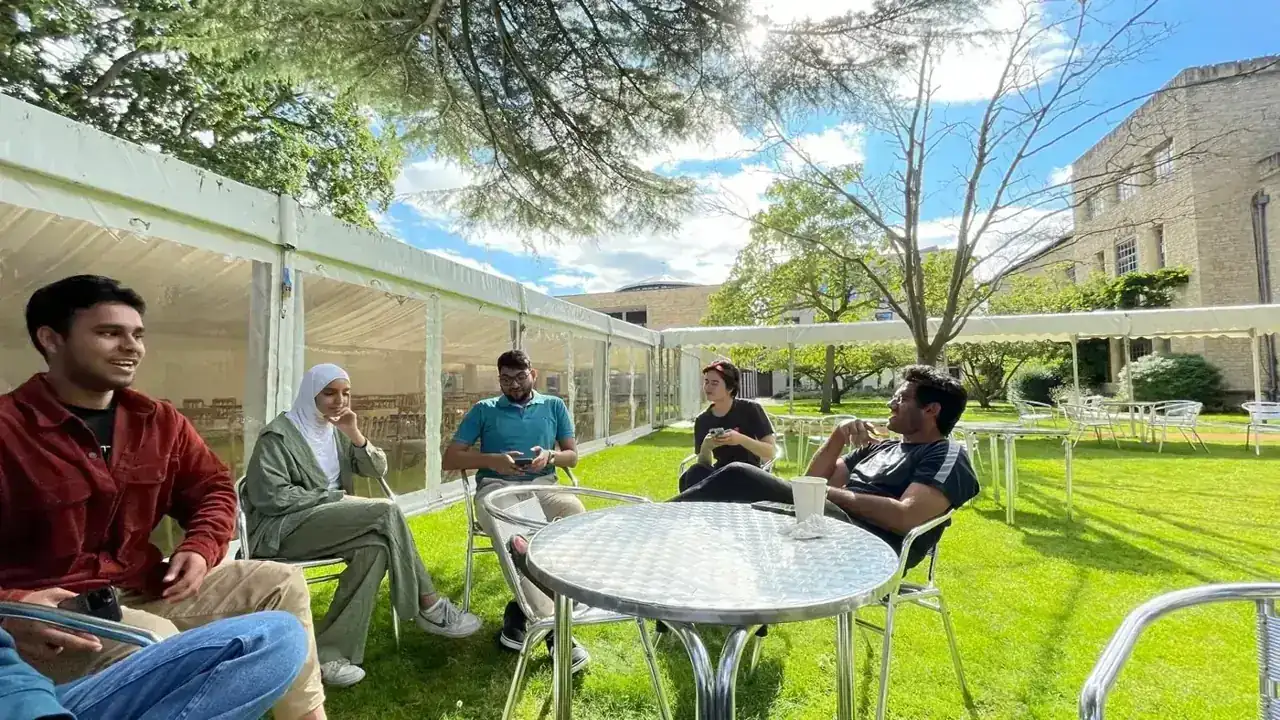 A small-group tutorial on a college lawn
